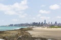 Beach, rocks, skyscrapers and clouds