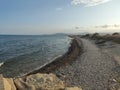 Beach. Rocky beach empty of people. Cozy and calm image next to the Mediterranean Sea and the waves breaking on the shore.