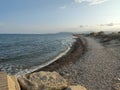 Beach. Rocky beach empty of people. Cozy and calm image next to the Mediterranean Sea and the waves breaking on the shore. Royalty Free Stock Photo