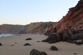 a beach with rocky coastline next to a cliff face near water Royalty Free Stock Photo