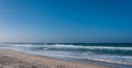 Beach with rough sea in a sunny day Royalty Free Stock Photo