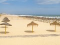 Beach with rusitc straw sunshades Royalty Free Stock Photo