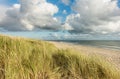 Beach with sand dunes and marram grass, blue sky and clouds in soft evening sunset light. Hvidbjerg Strand, Blavand Royalty Free Stock Photo