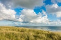 Beach with sand dunes and marram grass, blue sky and clouds in soft evening sunset light. Hvidbjerg Strand, Blavand Royalty Free Stock Photo