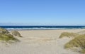 Beach with sand dunes and wild sea with waves breaking on a sunny day. Arteixo, Coruna, Galicia, Spain.