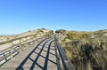 Beach with sand dunes and wooden boardwalk with blue sky. Arteixo, Coruna, Galicia, Spain.