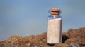 Beach sand in glass bottle, standing on beach rock. Mana island, Fiji Royalty Free Stock Photo