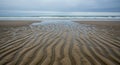 Beach Sand Patterns With Ocean Waves Under A Grey Sky Royalty Free Stock Photo