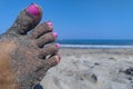 Beach sand on a woman feet with nails painted with nails polish Royalty Free Stock Photo