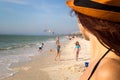 Sandy beach family holiday, pretty woman detail watching children playing on the sun in swimwear at beautiful sea beach in Florida Royalty Free Stock Photo