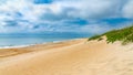 Beach scene with sand dunes, grass and waves of Atlantic ocean Royalty Free Stock Photo