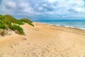 Beach scene with sand dunes, grass and waves of Atlantic ocean Royalty Free Stock Photo