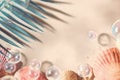 A beach scene shows colorful shells scattered on soft sand with bubbles floating around. Palm leaves are visible in the upper Royalty Free Stock Photo