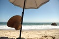 Beach scene. Straw Hat and Umbrella on Sand. Royalty Free Stock Photo