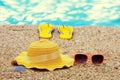 Sun straw hat, flip flop sandals, and sunglasses lying on the beach Royalty Free Stock Photo