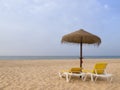 Beach scene with sunbeds and straw umbrella. Summer beach vacation concept Royalty Free Stock Photo