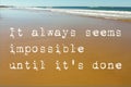 Beach Scene of wet sand with waves in the background and the motivational quote it always seems impossible until it`s done