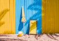 Beach Scene with Yellow Deck Chair, Umbrella, and Ball Against Wooden Wall Royalty Free Stock Photo