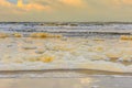 Beach and sea with breakers with thick white and cream-coloured foam Royalty Free Stock Photo