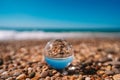 Beach with sea photographed through a crystal ball. The picture in the ball is in focus and the background is out of focus. Royalty Free Stock Photo
