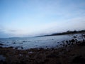 Beach sea scene view with deep blue sky and brown beach sand and stones Royalty Free Stock Photo