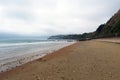 Beach Shoreline on Overcast Day with Sea Wall and Distant Cliff Royalty Free Stock Photo