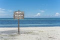 A beach sign posted at the beachfront. A nudist beach or naturist resort