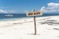 A beach sign posted at the beachfront. A nudist beach or naturist resort