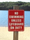 Beach sign warning no swimming unless lifeguard on duty Royalty Free Stock Photo