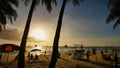 Beach with silhouettes of tourists among palm trees on the island of Boracay. Palm trees in the rays of sunset Royalty Free Stock Photo