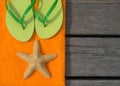 Beach slippers, towel and starfish on wood background Royalty Free Stock Photo