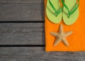Beach slippers, towel and starfish on wood background Royalty Free Stock Photo