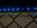 Beach soccer field through the fence mesh. Sand play concept. Competition sponsors. View of the viewer