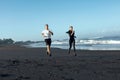 Beach. Sport Couple Running During Morning Workout. Handsome Man And Sexy Woman In Fashion Sporty Outfit.