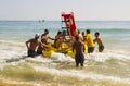 Beach staff and Holiday makers in hired Pedalos fight against the incoming surf to get out into calmer water at the beach in Albuf Royalty Free Stock Photo