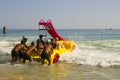 Beach staff and Holiday makers in hired Pedalos fight against the incoming surf to get out into calmer water at the beach in Albuf Royalty Free Stock Photo
