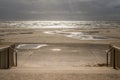 Beach on a stormy day with sun rays breaking through the clouds Royalty Free Stock Photo