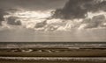 Beach on a stormy day with sun rays breaking through the clouds Royalty Free Stock Photo