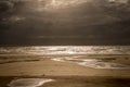 Beach on a stormy day with sun rays breaking through the clouds Royalty Free Stock Photo