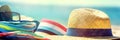 Beach straw hat and colorful clothes on sand on sea shore. Summer vacation concept. Created with generative Ai