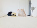 Beach straw hat and Louis Vuitton bag on the white linen of the bed
