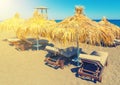 Beach with straw umbrellas and wooden sunbeds on island Satorini, Greece, Europe Royalty Free Stock Photo