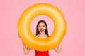 Beach style Travel daydream concept. Positive girl look through colorful rubber rings enjoying rest isolated on yellow