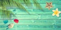 Beach and summer background with blue planks, palm tree branch and seashells