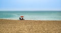 Beach summer couple on vacation holiday relax in the sun on their deck chairs under a red umbrella Royalty Free Stock Photo