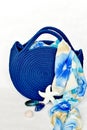 Royal blue knitted beach handbag with floral scarf background Royalty Free Stock Photo