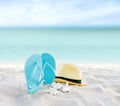 Beach summer holiday background. Flip flops and hat on sand near ocean. Summertime accessories on seaside. Tropical vacation Royalty Free Stock Photo