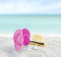 Beach summer holiday background. Flip flops and hat on sand near ocean. Summertime accessories on seaside. Tropical vacation Royalty Free Stock Photo