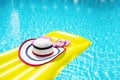 Beach summer holiday background. Inflatable air mattress, flip flops and hat on swimming pool. Yellow lilo and summertime Royalty Free Stock Photo