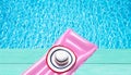 Beach summer holiday background. Inflatable air mattress and hat on blue wooden floor near swimming pool. Pink lilo and summertime Royalty Free Stock Photo